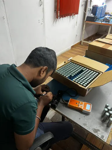 చేత్తో సెల్స్ అసెంబుల్ చేస్తూ
